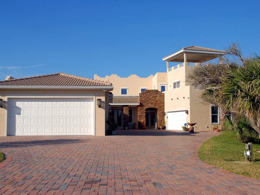 Red brick paver driveway in front of a stucco home
