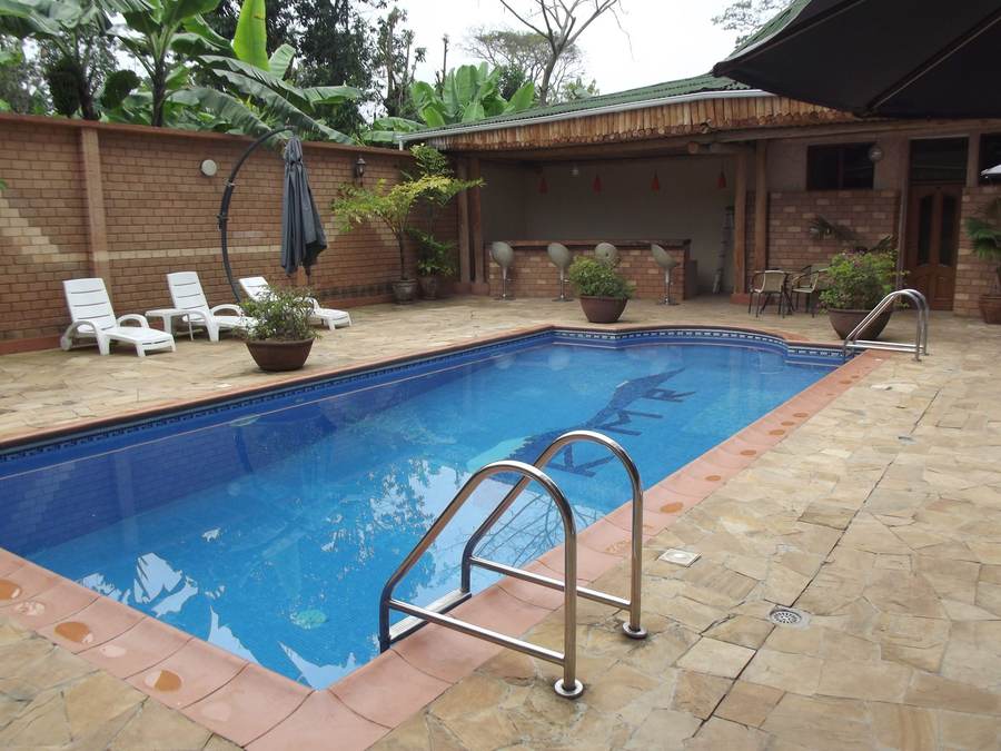 Backyard pool with a tan paver pool deck and lounge chairs